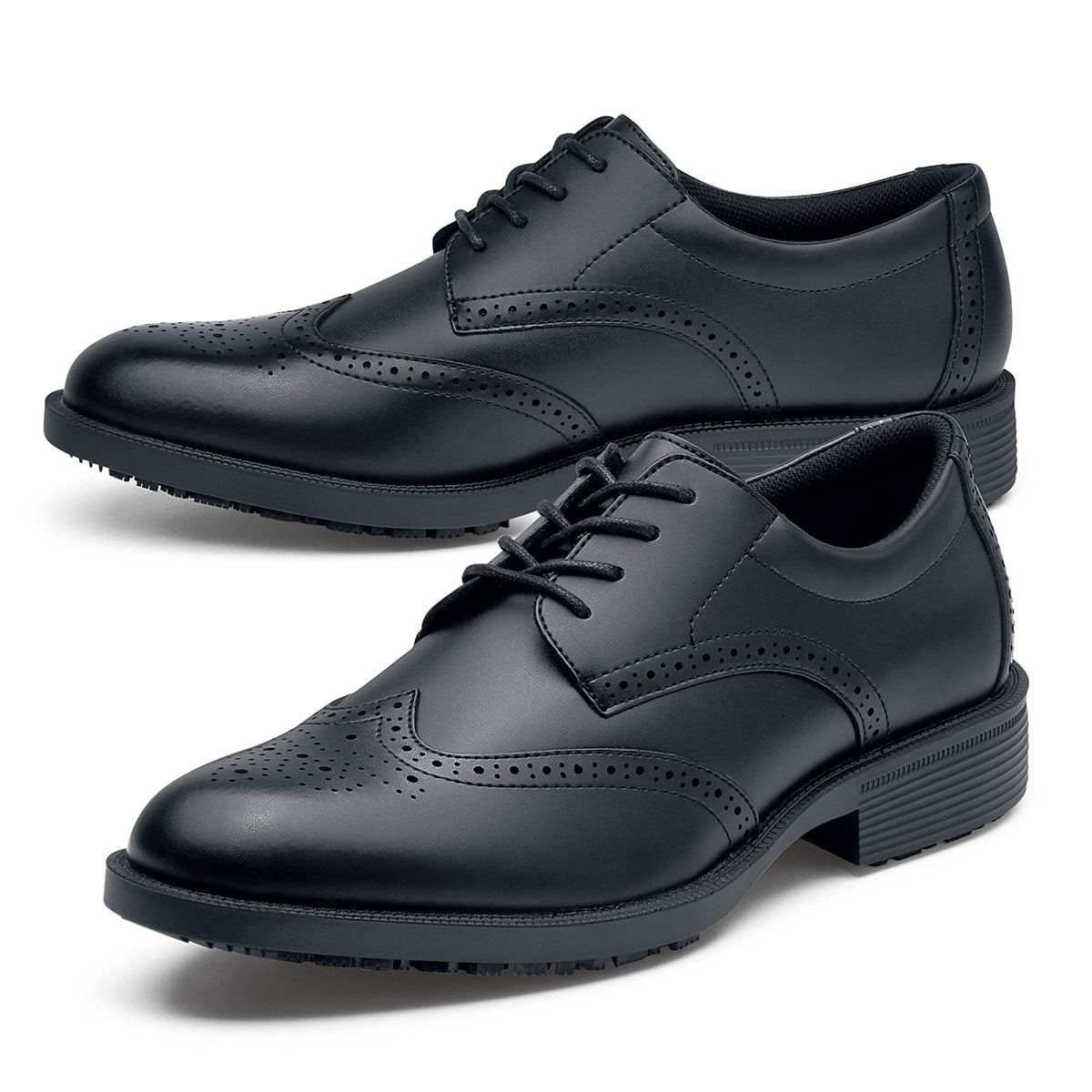 The Executive Wing Tip IV from Shoes For Crews, is an slip resistant dress shoe with a water resistant breathable leather upper to provide industry leading levels of grip and durability, pair seen from the left side, emphasised on the tip of the left  shoe.