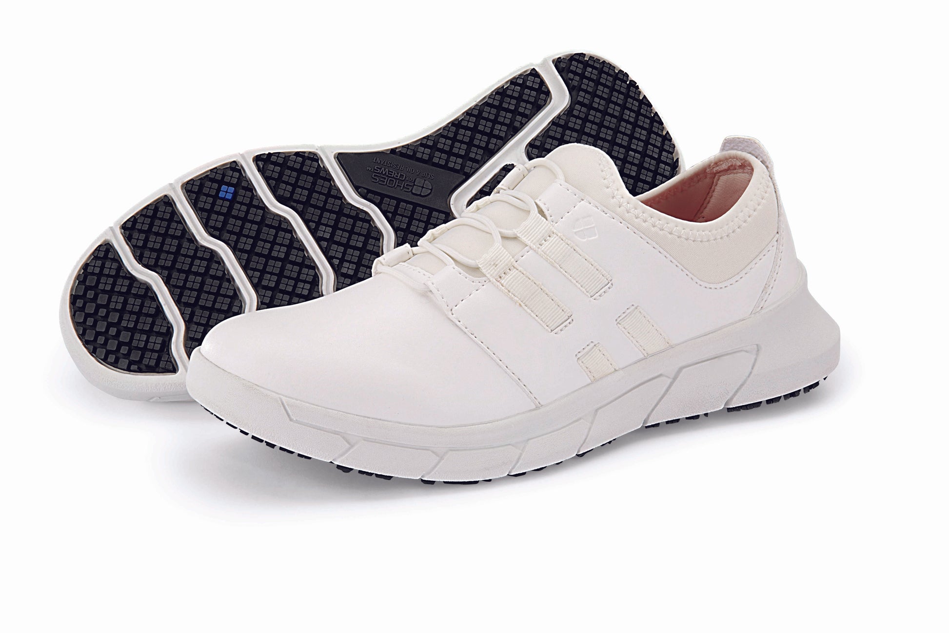 The Karina White by Lila from Shoes For Crews are black slip-resistant trainers that are lightweight and have Flex Tread technology, pair seen from the left side and the sole.