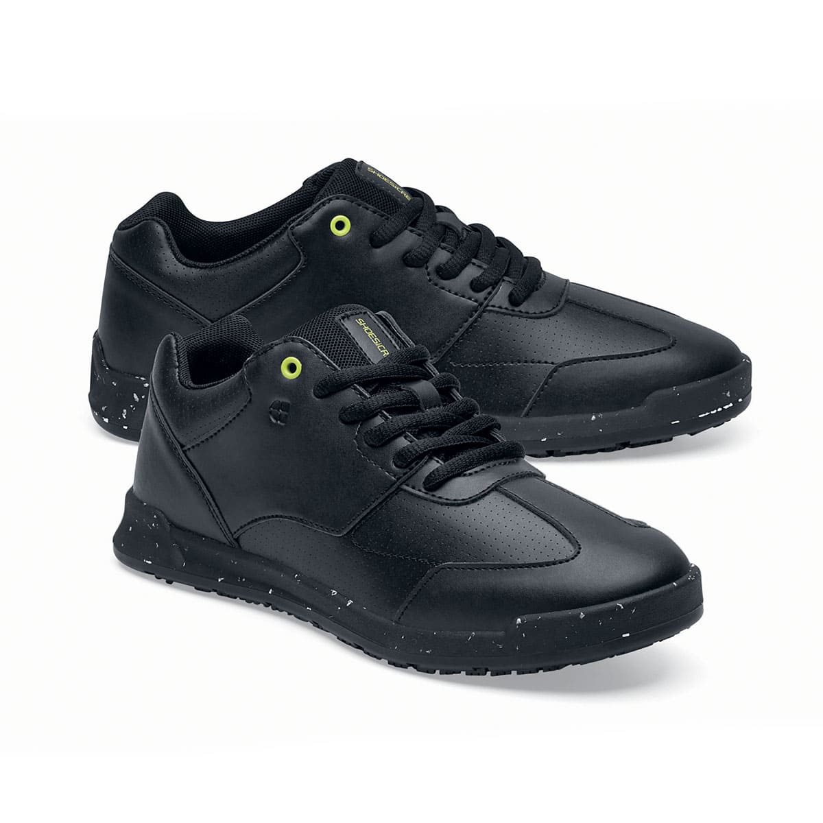 The Liberty Eco from Shoes For Crews are sustainable, slip-resistant trainers that provide comfort and safety throughout the day, pair seen from the right side, emphasised on the tip of the right shoe.