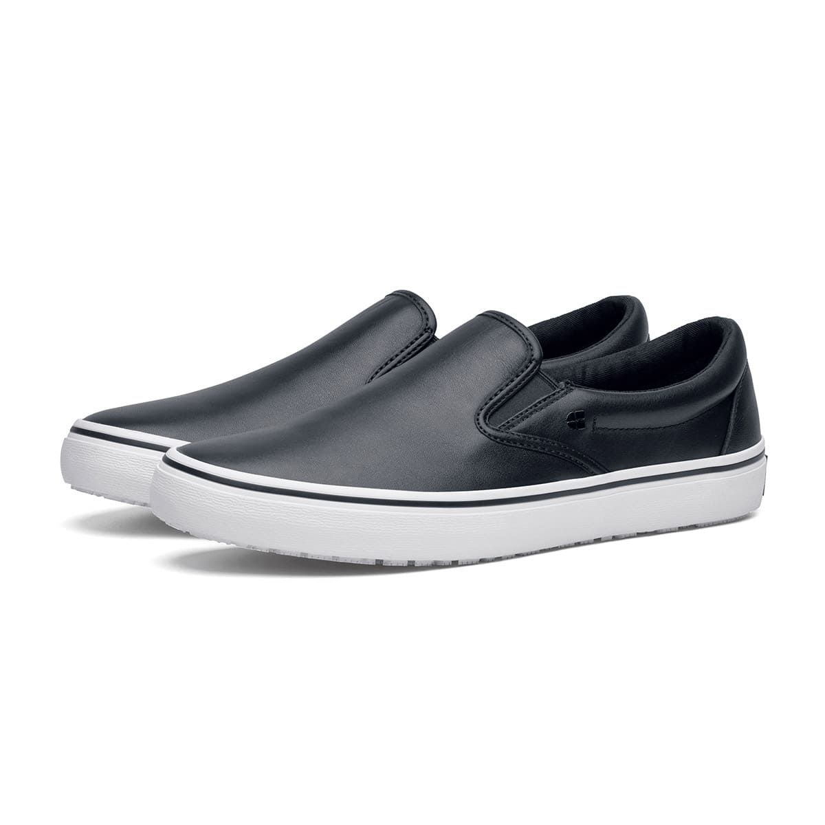 The Merlin Slip On Black and White from Shoes For Crews are slip-on trainers that are slip-resistant, lightweight, easy to clean and water-resistant, pair seen in profile on the left.
