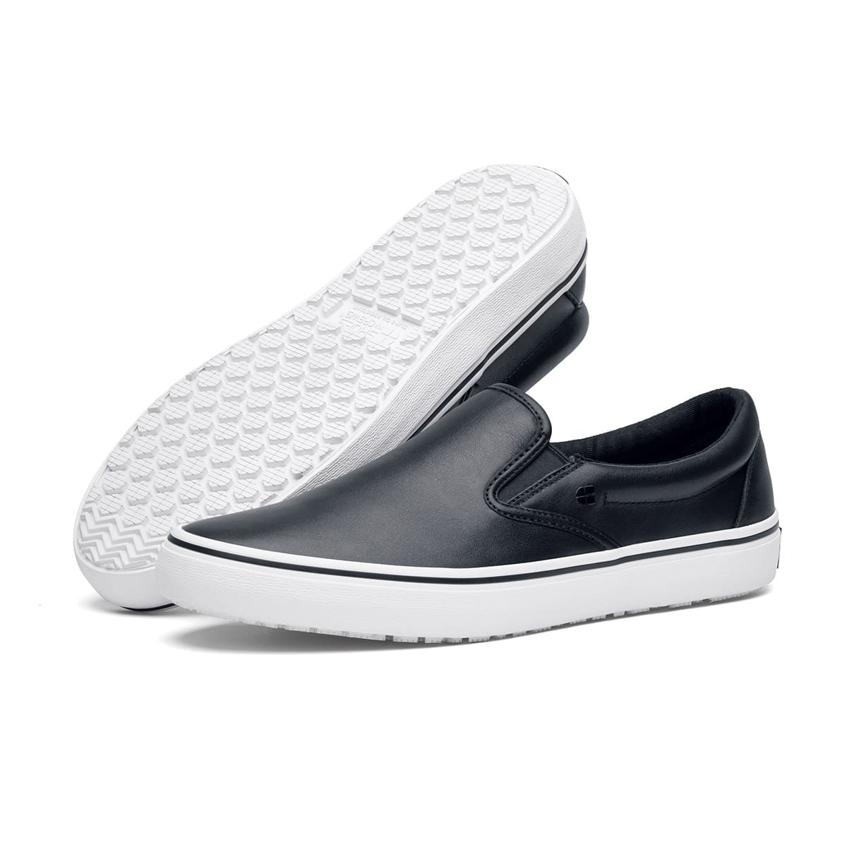 The Merlin Slip On Black and White from Shoes For Crews are slip-on trainers that are slip-resistant, lightweight, easy to clean and water-resistant, pair seen from the left side and the sole.